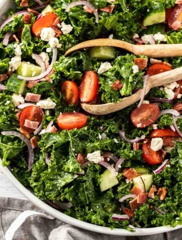 kale salad with tongs in a bowl